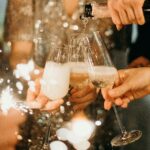 People toasting with champagne glasses amidst sparklers at a festive party.